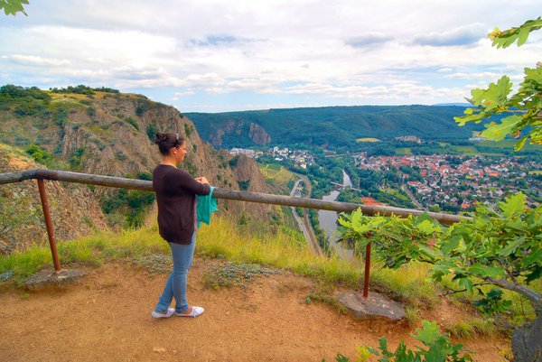 Wanderin steht am Aussichtspunkt auf dem Rotenfels mit Blick auf den Ortsteil Ebernburg